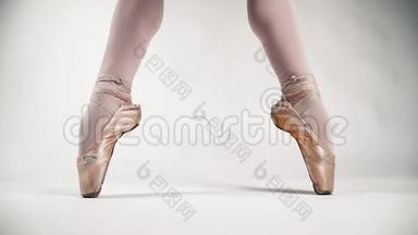 美丽的芭蕾舞脚尖鞋站在芭蕾舞的一个姿势。 在白色背景上的芭蕾舞演员。 古典舞。